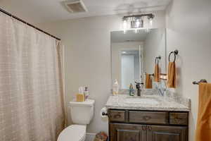 Bathroom with a shower with curtain and vanity