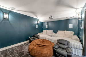 Carpeted cinema room with baseboards