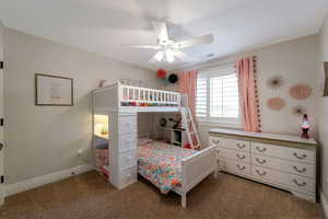Bedroom with ceiling fan and dark colored carpet
