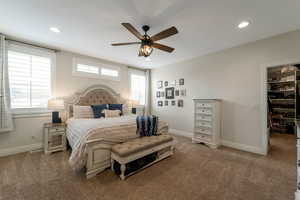 Carpeted bedroom featuring a walk in closet, ceiling fan, and recessed lighting