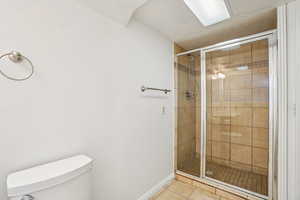 Bathroom with a stall shower and light tile patterned floors