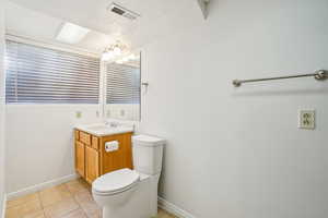 Bathroom with light tile patterned floors and vanity