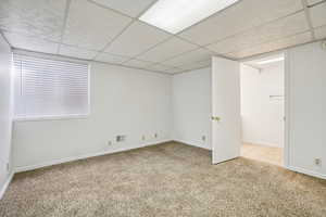 Unfurnished room with a paneled ceiling and light colored carpet