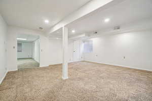 Finished below grade area featuring light carpet and recessed lighting