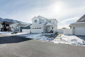 Traditional home with a gate, a residential view, and an attached garage