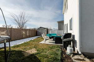 Fenced backyard with a storage shed, an outdoor living space, and a patio area