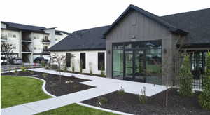 Rear view of house with roof with shingles, french doors, board and batten siding, and a yard