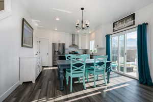 Dining area featuring dark wood-style floors, a chandelier, and recessed lighting