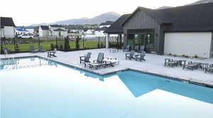 Community pool featuring a patio, a mountain view, and a residential view