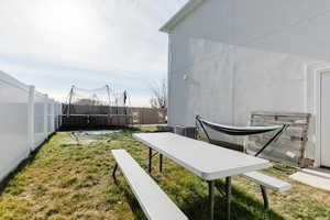 Fenced backyard with a trampoline and a patio