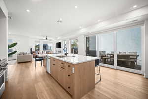 Kitchen featuring light wood-style floors, healthy amount of natural light, a kitchen island with sink, recessed lighting, and appliances with stainless steel finishes