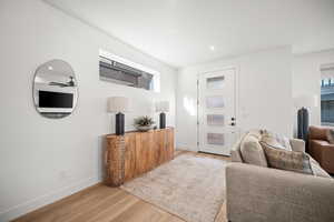 Living room featuring light wood finished floors, ceiling fan, and recessed lighting