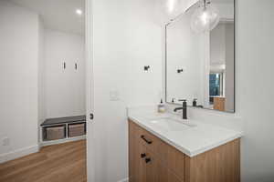 Bathroom featuring vanity, wood finished floors, and recessed lighting