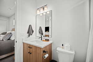 Half bathroom featuring vanity and toilet