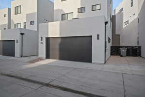 View of front of property featuring concrete driveway, stucco siding, and a garage