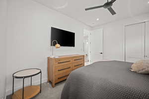 Bedroom with light colored carpet, ceiling fan, a closet, and recessed lighting