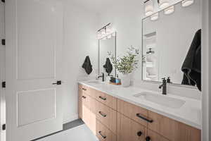 Full bathroom with double vanity and light tile patterned floors