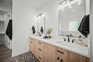 Bathroom featuring double vanity, dark tile patterned flooring, and a spacious closet