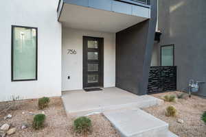 Property entrance with stucco siding and a porch