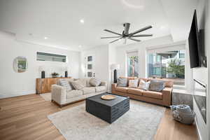 Living room with recessed lighting, light wood finished floors, and a ceiling fan