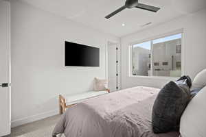 Carpeted bedroom with a ceiling fan and recessed lighting