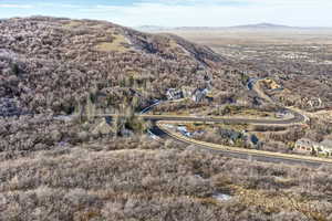 Aerial view of property and surrounding area featuring a mountain backdrop and nearby suburban area