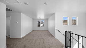 Empty room featuring light colored carpet and baseboards