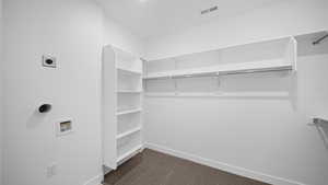Walk in closet with dark colored carpet