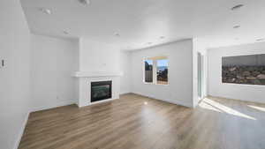 Unfurnished living room with a large fireplace and dark wood finished floors