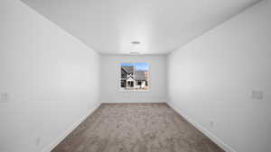 Carpeted spare room with baseboards