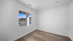 Spare room featuring baseboards and wood finished floors