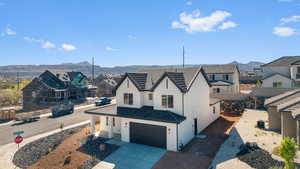 View of front facade featuring a residential view, stucco siding, concrete driveway, a garage, and a mountain view