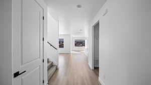 Corridor with stairway and light wood-type flooring
