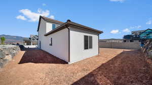 View of property exterior with a fenced backyard, a mountain view, and stucco siding