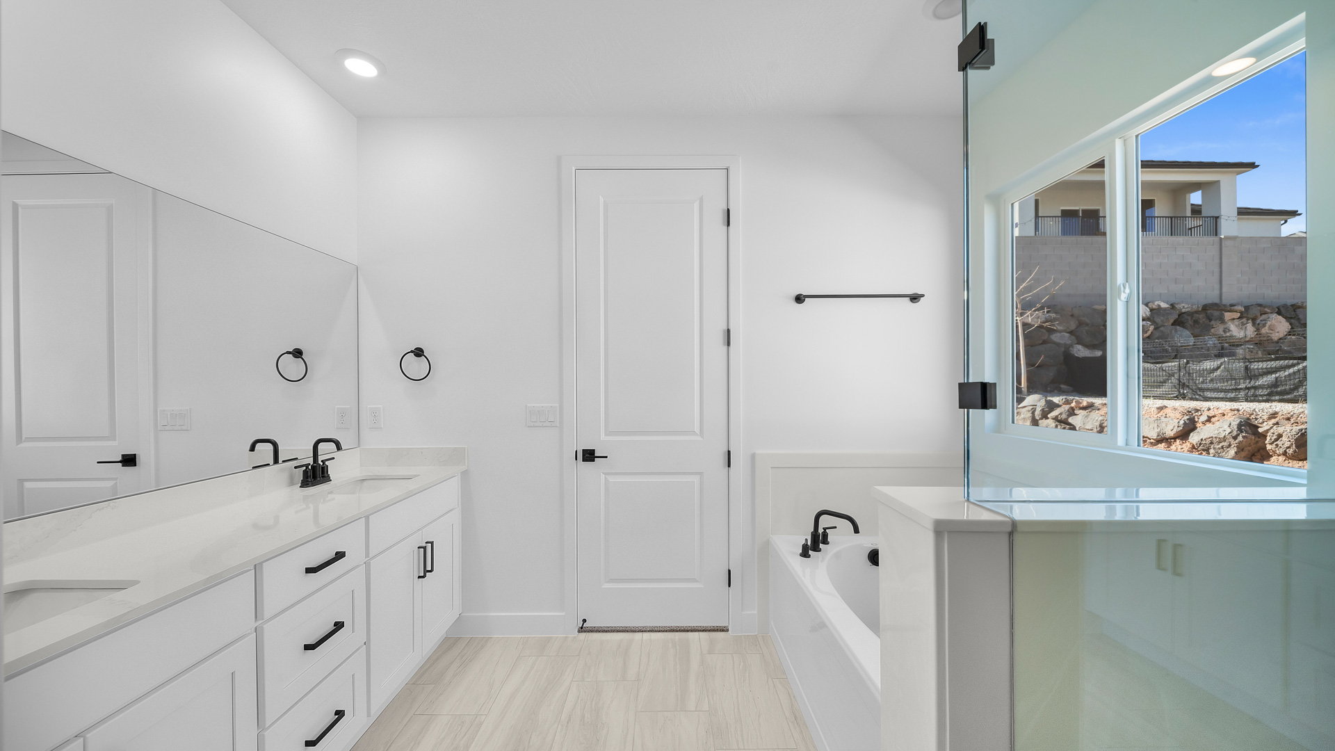 Full bathroom with double vanity, a bath, and recessed lighting