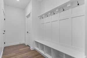 Mudroom with wood finished floors and baseboards