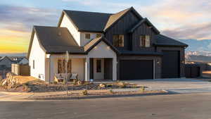 Modern farmhouse style home with a mountain view, a porch, board and batten siding, and driveway
