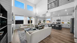 Living room featuring recessed lighting, dark wood-style flooring, and a high ceiling
