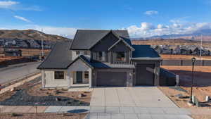 Modern farmhouse style home featuring a residential view, a mountain view, board and batten siding, and concrete driveway
