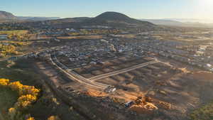 Aerial view of property and surrounding area featuring a mountain backdrop and nearby suburban area