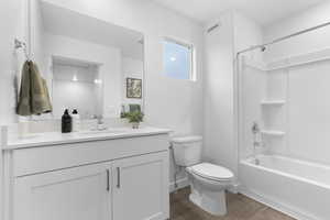 Bathroom featuring vanity, shower / bath combination, and wood finished floors