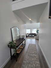 Hall featuring baseboards and dark wood-type flooring