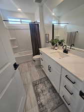 Bathroom with vanity, shower / bath combination with curtain, and recessed lighting