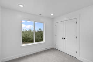 Unfurnished bedroom featuring carpet floors, a closet, and recessed lighting