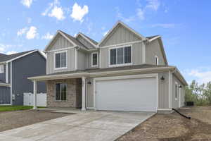 View of front of property with an attached garage, driveway, board and batten siding, and a porch