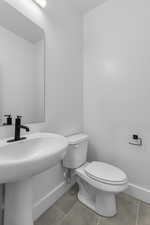 Half bathroom on the first floor featuring toilet and tile patterned floors