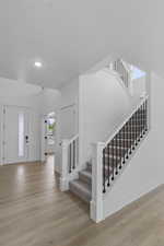 Entrance foyer featuring light wood-style floors and stairs