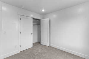Unfurnished bedroom featuring carpet flooring and a closet