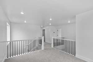 Corridor featuring an upstairs landing, carpet, and recessed lighting