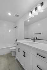 Full bath with vanity, shower / bath combination, dark tile patterned floors, and recessed lighting